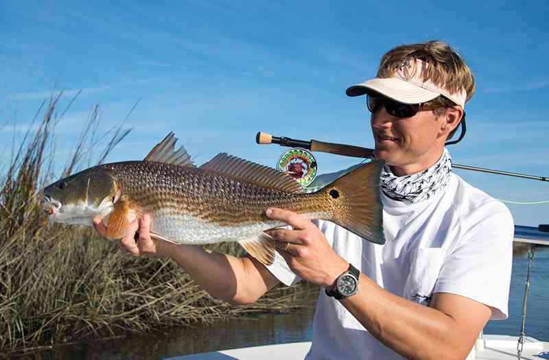 a picture of an angler with a redfish caught on a myrtle beach fishing charter